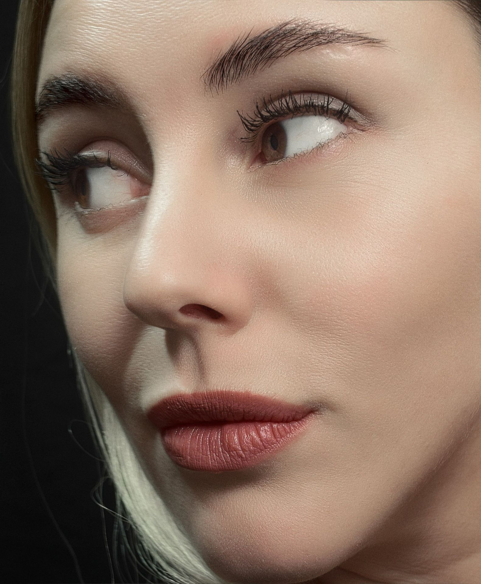 a close up of a woman's face with a black background